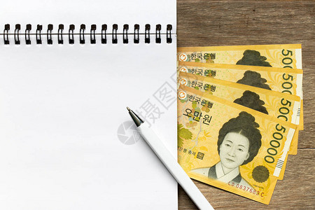 带笔和5万韩圆krw以木制表格背景纸币图片