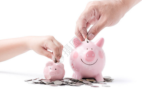 父亲和孩子亲手把硬币放进小猪银行图片