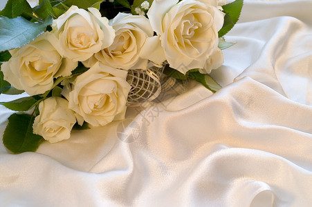 丝绸背景上的白色婚礼玫瑰图片