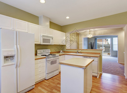 白色厨房橱柜配有钢铁电器和图片