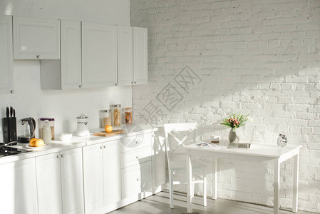 带炊具的白色现代厨房的阳光图片