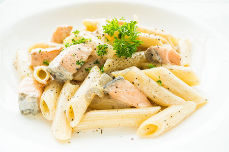 白盘中三文鲑鱼意大利食品风格的PenneCubam图片