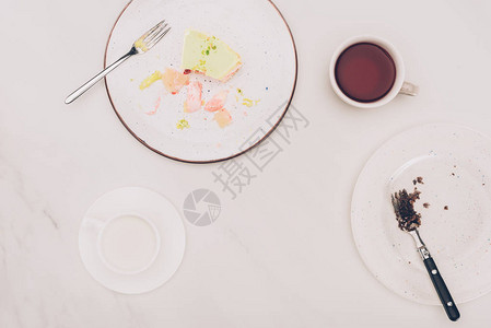 白色桌面上带有蛋糕和饮料片的排列好的图片