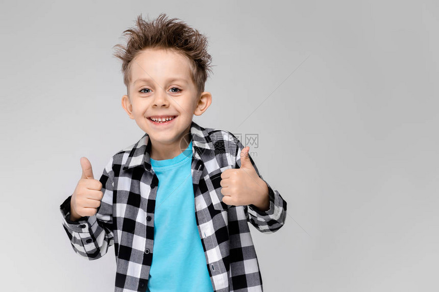 灰色背景的迷人快乐的孩子男孩的头发都竖起来了这个男孩有一个发型男孩在课图片