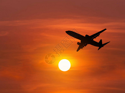 日落时剪影客机飞向太阳上方的高空图片