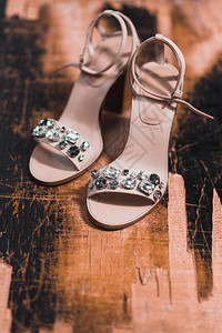 新娘鞋与木制背景上的珠宝图片