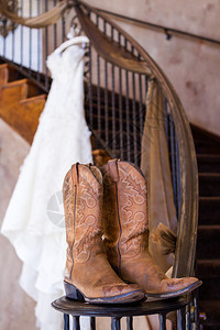 挂在衣架上的复古婚纱搭配牛仔靴背景图片