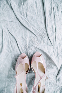粉色女高跟鞋在纺织背景上图片