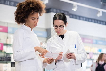 两位女药剂师阅读新产品包装中的信息图片