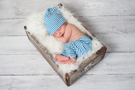 新生婴儿穿着蓝色和白条纹睡衣图片