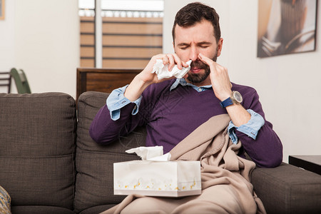 使用鼻喷剂在家中抗击流感的患病青背景图片