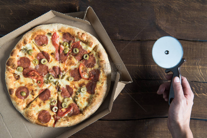 在纸板盒和人手披萨切饼机中最美味图片