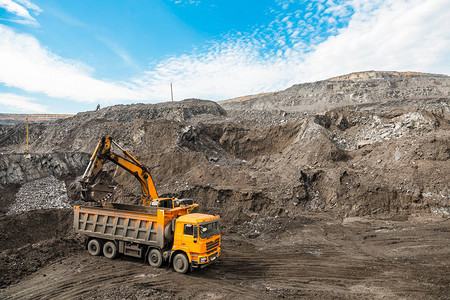大型采石场自卸车将岩石装入自卸车将煤炭装载到车身工作卡车中采矿卡车采矿机械背景图片