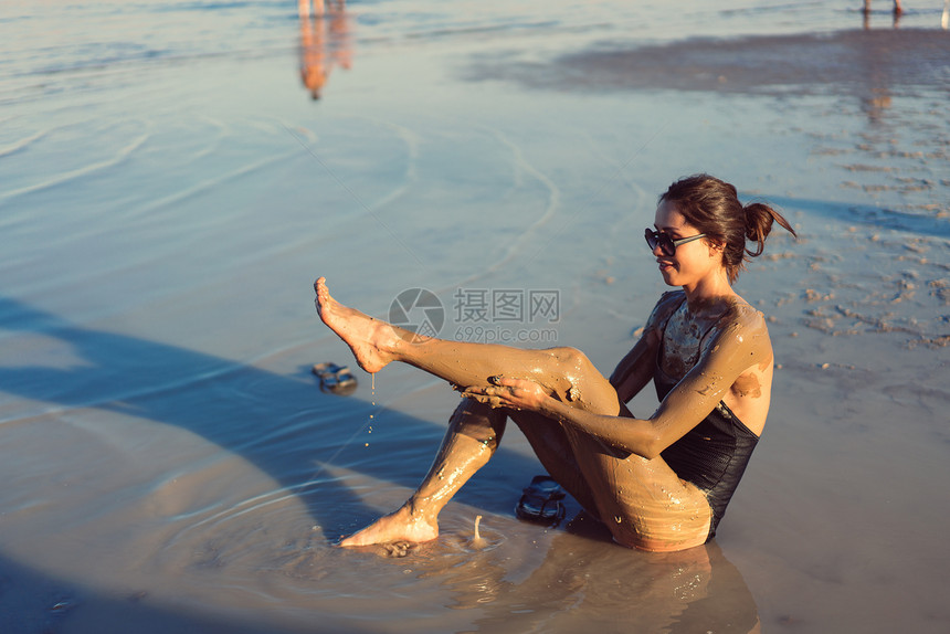 一位年轻女子享受来自以色列死海的天然矿物泥土图片