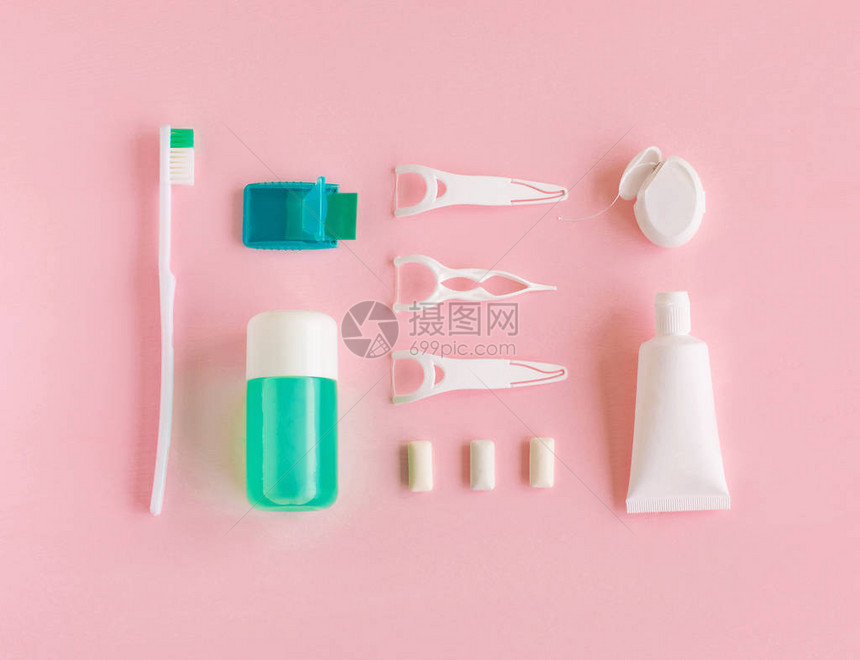 牙刷牙膏洗涤和咀嚼口香糖套在粉红色背景上图片