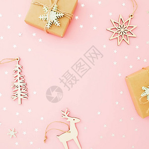 圣诞节框架圣诞礼物装饰木玩具和粉红背景的银面条平底地图片