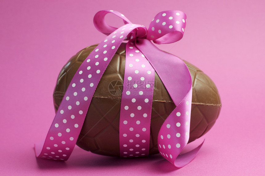 大复活节巧克力复活节彩蛋粉红色的波尔卡圆点丝带绑在弓上与漂亮的女粉图片
