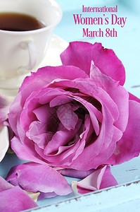 快乐的国际妇女节问候与粉红色的玫瑰和下午茶托盘在粉红色的背图片