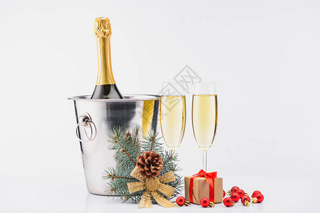 紧贴地看到桶里一瓶香槟香槟杯子和灰色本底的包着圣诞图片