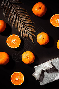 黑色背景的新鲜橘子装饰树枝和礼图片