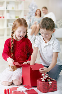 两个小孩在家里检查圣诞礼物盒家图片