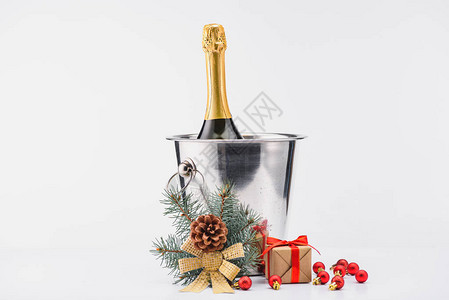 紧贴地看到桶里一瓶香槟圣诞节玩具和灰色面的包裹礼物图片