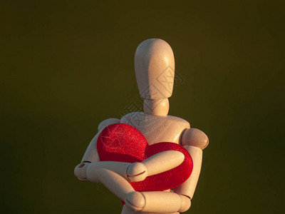Woodenmannequin拥抱他的心脏用他的双手图片