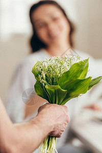 男人在家里给女友送花束的鲜花图片