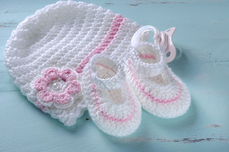 育婴少女粉色和白条纹羊毛靴帽子和奶油假体图片