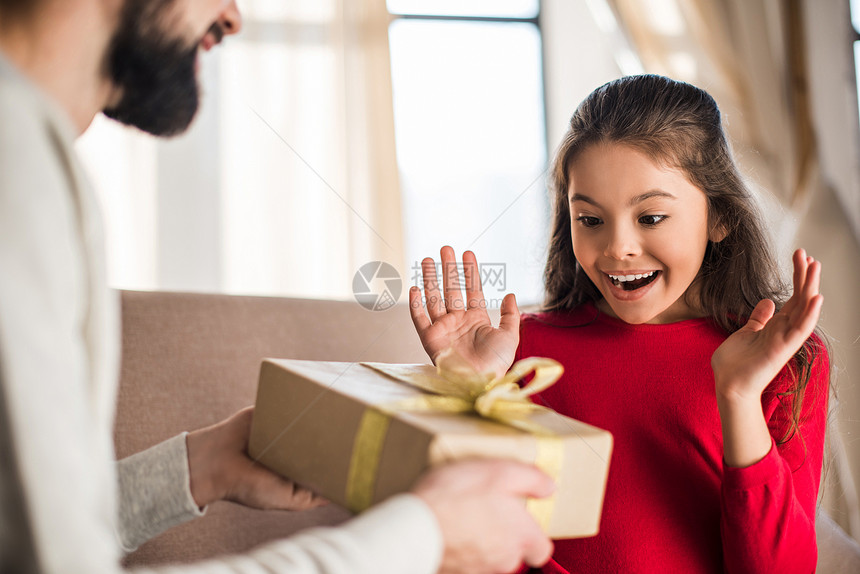 父亲给兴奋的女儿送礼盒图片