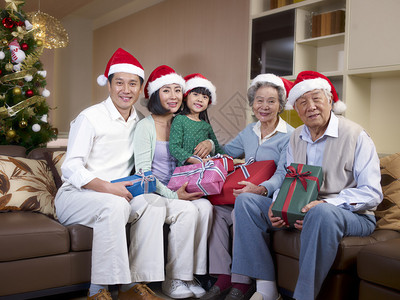 一个带圣诞帽子和礼物的亚洲家图片