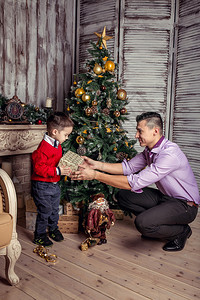 父亲在圣诞树下给他儿子图片