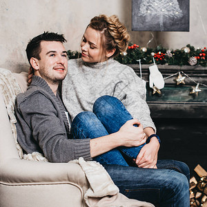 坐在圣诞节装饰品的一对漂亮的夫妇圣图片