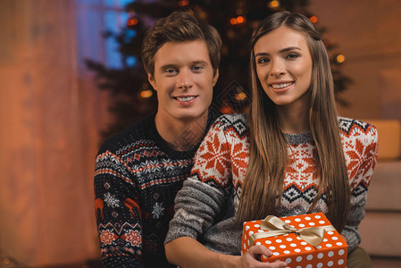 穿着毛衣和圣诞礼物的一对微笑情侣肖像图片