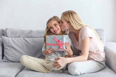母亲给女儿送生日礼物亲吻她背景图片