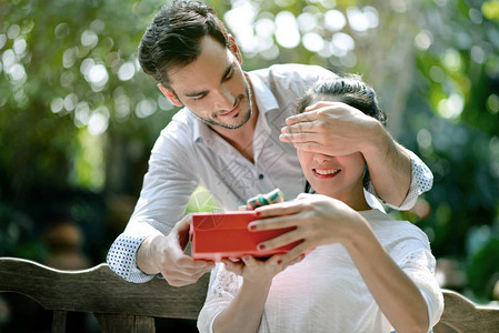 年轻男人在遮着女友的眼睛送她图片