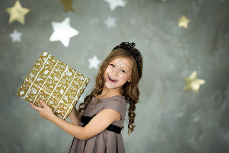 快乐的小女孩肖像和圣诞礼物盒装满了星图片