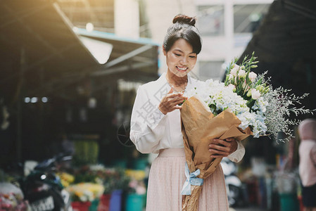 快乐的越南漂亮女人手拿着漂亮的花束看图片