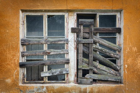 一栋废弃旧建筑的木板窗墙上有两个旧木板窗图片