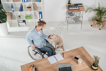 残疾人在轮椅上抚狗时图片