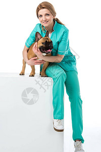 坐在白色立方体上时微笑着的兽医拥抱图片