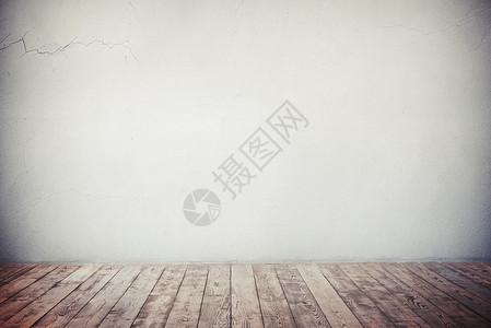 灰色空墙有裂缝和天然棕褐木地板充图片