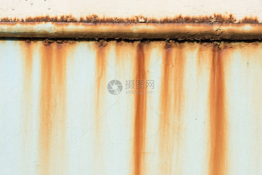 墙壁背景上旧生锈管道的特写视图图片