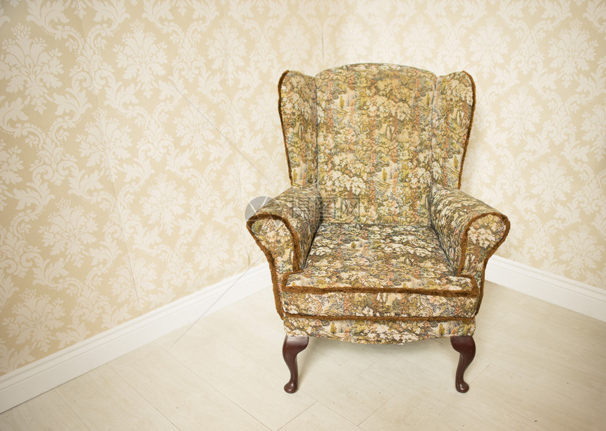 时尚的空软垫金色复古扶手椅站在房间的角落里图片