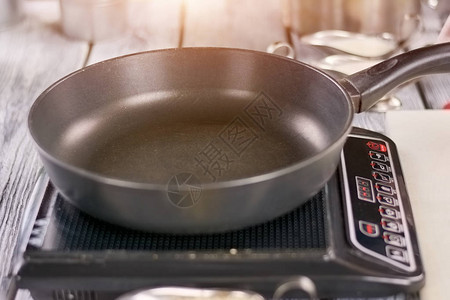 电炉上的空煎锅黑色煎锅打开电炉烹饪和食图片