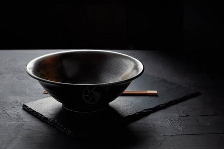 黑石板上空碗和筷子的特写视图图片