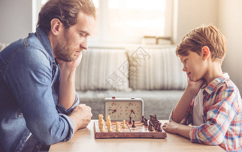 父亲和儿子在下棋同时图片