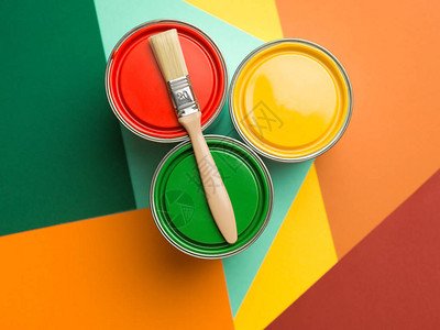 三罐黄绿色和红油漆涂刷多彩几图片