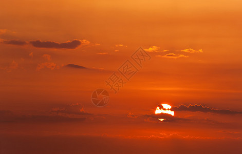 夕阳红的天空有太阳和云彩图片