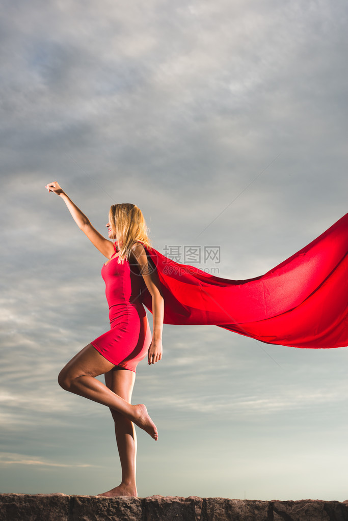 穿红裙子的金发女人穿着红裙和红色地皮的红花纹在户外扮成超级图片